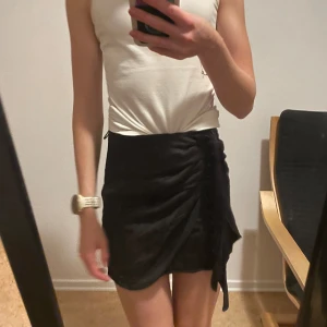 Satinkjol - Svart satinkjol med knytning fram. Bra skick