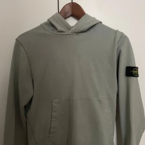 Stone Island hoodie junior  - En Stone Island hoodie i junior storlek 12 år/156 cm. Den är i använt men i bra skick utan några defekter.  Inköpt på NK Göteborg för 1900 kr.  Hör av dig vid intresse :)