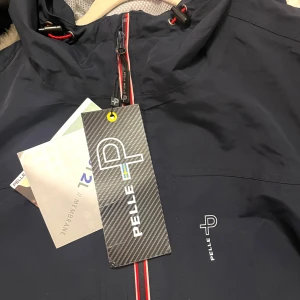 Regnjacka Pelle P friluftsliv  - Windproof, rainproof, breathable  Vindjacka regnjacka seglarjacka. Finns i M/L/XL, beställt och glömt skicka tillbaka därav låga priset.  Den har meshfoder och justerbar fast huva. Fickorna har vattentäta dragkedjor. Ordinarie pris 2800kr.