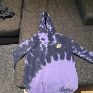 H&M - Cool hoodie i lila och svart med ett unikt tryck på ryggen som säger 'Oh My Aching Tentacles'. Hoodien har en stor ficka framtill och en bekväm passform. Perfekt för en avslappnad stil. Har en olje fläck på magfickan 