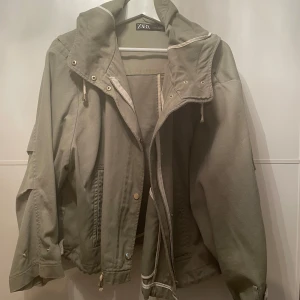Grön jacka från Zara - Säljer en snygg grön jacka från Zara med huva och dragkedja. Använd men i mycket bra skick. 