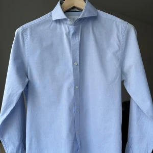 Bläck ljusblå skjorta, tailored fit storlek S - Bläck ljusblå skjorta, tailored fit storlek S. Lättare missfärgning armhålor se bilder. 100% bomull. Jag säljer många skjortor i samma storlek, kolla gärna på mina övriga annonser för att skapa ett paket. Axelbredd: 45 cm Längd: 73 cm  Kostymskjorta, business, finskjorta.