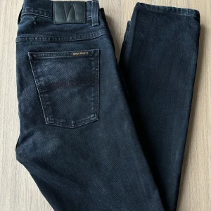 Nudie Jeans, storlek W32 L32 - Jeans från Nudie, troligtvis Grim Tim. Slim fit. Bra skick, se bilder för litet hål baktill, kan lämnas in och fixas gratis hos Nudie vid behov. Snygg grå/svart tvätt.   En stor fördel med Nudies jeans jämfört mot Levis, Tiger of Sweden, Replay, Lee, Acne, dondup osv. är att du kan lämna in dem gratis för reparation eller uppläggning i Stockholm, Göteborg eller Malmö. På så vis förlängs livslängden rejält.  Hör av dig om du har några funderingar.