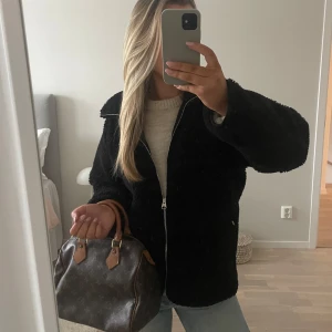 Svart teddyjacka arket - Mysig svart teddyjacka med dragkedja framtill och två sidofickor med dragkedjor. Har en krage som är perfekt för kyliga dagar när du vill hålla dig varm och stilren. Från arket - nypris 1390. Sparsamt använd. 