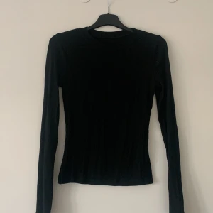 Svart långärmad topp från Shein - Säljer en stilren svart långärmad topp från Shein. Perfekt för en enkel och elegant look. Tillverkad i mjukt och stretchigt material för en bekväm passform. Passar bra till både jeans och kjol.