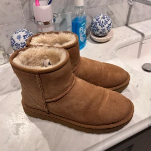 Bruna boots från UGG - Säljer ett par klassiska bruna UGG boots med mjukt foder inuti. De är perfekta för kalla vinterdagar. Bootsens utsida är i mocka. Och är endast använda 3-5 gånger!  Skorna är i storlek 41! Nypris ligger runt 2300kr! Skriv vid intresse!