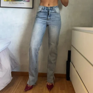 Ljusblå jeans med hög midja - Snygga ljusblå jeans med hög midja och rak passform. Trasiga i en av stropparna men det syns inte.