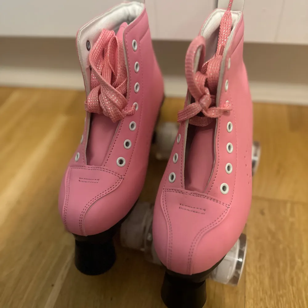 Snygga rosa rullskridskor med snörning och vita hjul. Perfekta för en rolig åktur. Storlek 37.. Kengät.