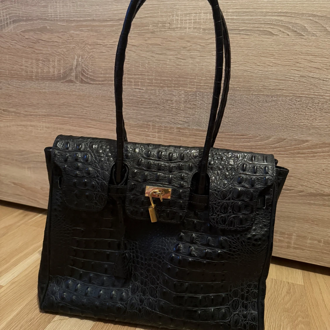 Svart krokodilpräglad handväska