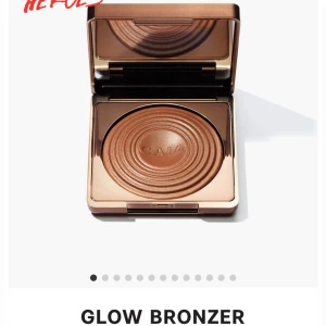 Glow Bronzer - En lyxig bronzer med en varm, gyllene ton som ger en solkysst look. Kommer i en elegant fyrkantig förpackning med spegel. Perfekt för att framhäva ansiktets konturer och ge en naturlig lyster.