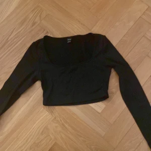 Svart croppad topp från Shein - Säljer en svart croppad topp från Shein i storlek Petite XS. Toppen har långa ärmar och en enkel design som passar perfekt till olika outfits.