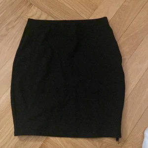 Svart kjol från Amisu - Snygg svart kjol från Amisu i en klassisk design. Perfekt för att matcha med olika toppar och accessoarer. Kjolen har en enkel och stilren look som passar till många tillfällen.