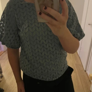 Blå blus med puffärmar - Säljer en stilren blå blus med puffiga kortärmar och ett diskret mönster. Perfekt för en chic och avslappnad look. Passar bra till både jeans och kjol. 