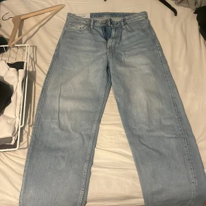 Ljusblå loose fit jeans från H&M - Säljer ett par ljusblå loose fit jeans från H&M. De har en avslappnad passform och klassisk femficksdesign. Perfekta för en casual look.