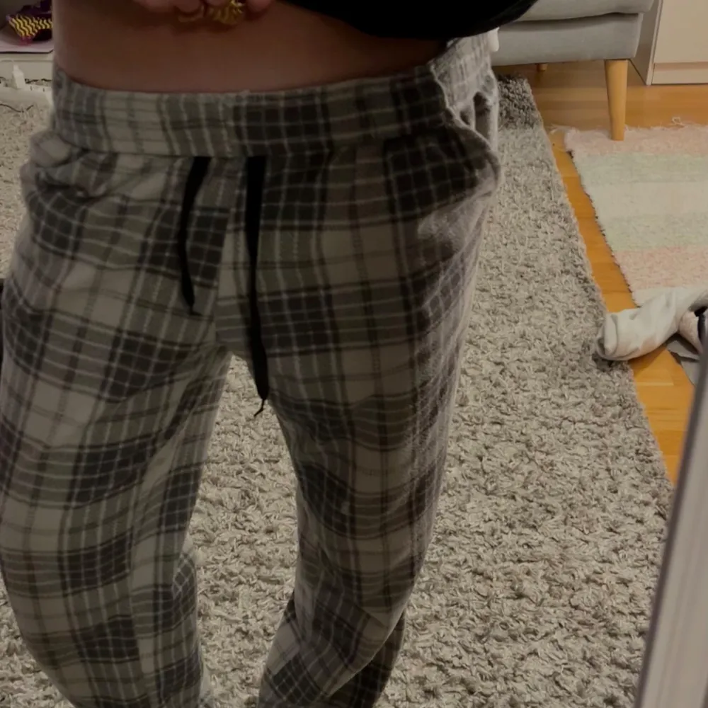 Säljer ett par bekväma pyjamas/mjukis byxor med rutigt mönster i grått och svart. Byxorna har en elastisk midja med snörning för justerbar passform. Dom är så sjukt sköna och mjuka! Helt oanvända! storlek xs/s🍸🩶 Köpta på en sportaffär så vet inte märket. Farkut & Housut.