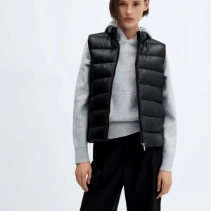 Svart dunväst - Snygg svart dunväst med dragkedja framtill. Perfekt för lager-på-lager under kyliga dagar. Västen har en stilren design och är lätt att matcha med olika outfits. Aldrig använd