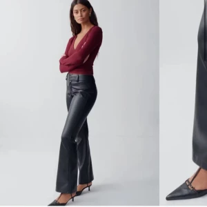 Svarta skinnbyxor - Snygga svarta skinnbyxor med hög midja och bootcut-stil. Perfekta för en trendig look med en elegant touch. Byxorna har en slät yta och ger en stilren siluett.