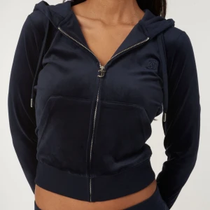 Mörkblå velourjacka med dragkedja - Snygg mörkblå velourjacka från Juicy Couture med dragkedja och huva. Jackan har långa ärmar och ribbade muddar. Den kommer tyvärr inte till användning men är i väldigt bra skick!🩷nypris 1300, pris kan diskuteras