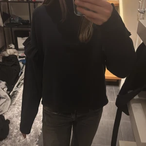 Mörkblå tröja med volangdetaljer - Säljer en mörkblå tröja med långa ärmar och volangdetaljer lite nedanför axlarna.Säljer då jag tycker den har blivit lite för kort.🩷