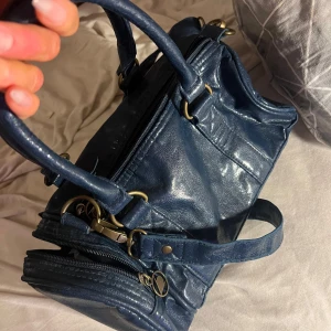 Blå axelväska från Dunlop vintage - Snygg blå axelväska från Dunlop i syntetmaterial. 