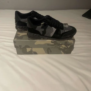 Valentino rockrunners  Garavani sneakers i camouflage - Snygga Valentino Garavani sneakers med ett coolt camouflagemönster i svart och grått. Skorna har snörning och kommer med originalförpackning och dustbag. Perfekta för en stilren look. Box och dust bag medföljer. 