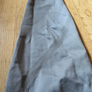 Grå leggings med ribbade detaljer - Snygga grå leggings med ribbade detaljer längs benen och midjan. Perfekta för en avslappnad stil eller träning i. De har en tight passform och är tillverkade i ett stretchigt material för extra komfort.