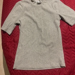 Grå glittrig topp från Kappahl - Snygg grå glittrig topp från Kappahl med trekvartsärm. Perfekt för att lägga till lite glitter i vardagen. Toppen har en enkel och stilren design. Nyår topp 🔥🔥s-xs 