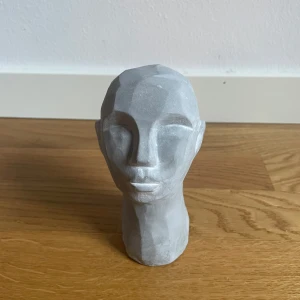 Dekorativ byst i grått - En stilren och modern dekorativ byst i grått. Perfekt som inredningsdetalj för att ge rummet en konstnärlig touch. Tillverkad i ett material som liknar sten, med en minimalistisk design.