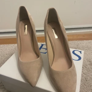 Beige pumps från Guess - Eleganta beige pumps från Guess i mocka med spetsig tå och hög klack. Perfekta för en stilren look.(Ny pris 1500kr) 💘