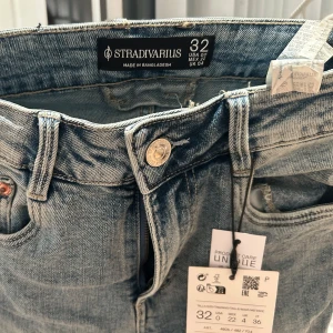Blå flared jeans från Stradivarius - Snygga blå jeans från Stradivarius i en klassisk design. De har en knapp och dragkedja framtill samt fem fickor. Perfekta för en avslappnad stil. Snygga flared och kommer passa er stockholmstil tjejer🩷