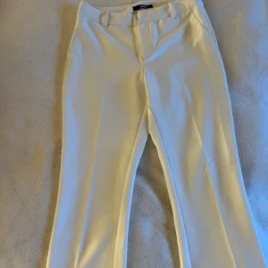 Vita kostymbyxor från Bik Bok - Snygga vita kostymbyxor från Bik Bok i storlek S. Byxorna har en klassisk design med raka ben och midwaist passform. Perfekta för en stilren old money look.