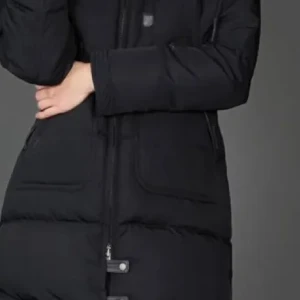 Svart dunjacka från Cedrico - Snygg och varm svart dunjacka från Cedrico med dragkedja och knappar. Perfekt för kalla dagar med sin långa design och vadderade stil. Jackan har praktiska fickor och en mysig huva . En liten söm har släppt vid dragkedjan men inget som påverkar .