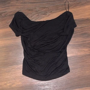 Svart backless topp från Gina Tricot - Svart enkel backless T-shirt från Gina Tricot. Öppen rygg och mjukt stretchigt material och använd ett par gånger
