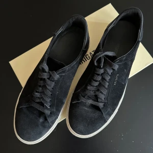 Svarta sneakers från Axel Arigato - Snygga svarta sneakers från Axel Arigato i mocka med vit sula och snörning. Perfekta för vintern. Kvitto finns