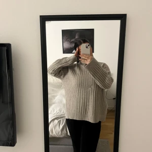 Beige ribbad stickad tröja - Säljer en mysig beige stickad tröja med ribbad struktur. Tröjan har en lös passform och långa ärmar,  storlek s