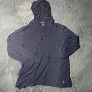 Ralph lauren hoodie - Säljer en stilren mörkblå hoodie från Polo Ralph Lauren med en liten röd logga på framsidan. Tröjan har långa ärmar och en bekväm huva med dragsko. Perfekt för en avslappnad look. Bra att skriva vid frågor 😃