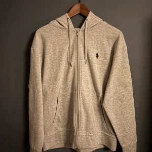 Grå hoodie från Polo Ralph Lauren - Säljer nu denna assnygga Zip Hoodie från Polo Ralph Lauren. Den har inga defekter och är i ett så gott som nytt skick. Tveka inte att höra va dig vid funderingar🙌