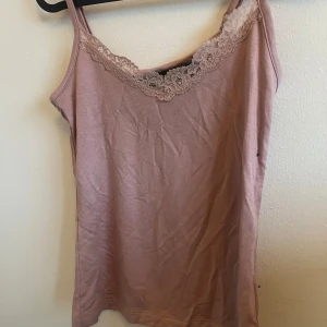 Rosa linnetopp från Lager 157 - Säljer en söt rosa linnetopp från Lager 157 i storlek XS. Toppen har fina spetsdetaljer vid halsringningen och smala axelband. Perfekt för sommardagar eller som ett lager under en kofta. 💖