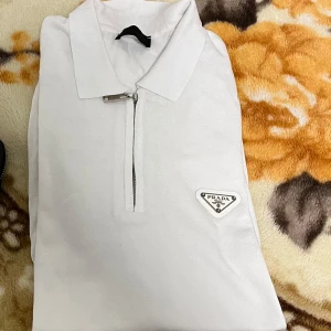 Prada t shirt  - Hej jag säljer min Prada t shirt som jag har köpt på sommaren använd bara då. Den är i väldigt bra skick och sitter väldigt fint.