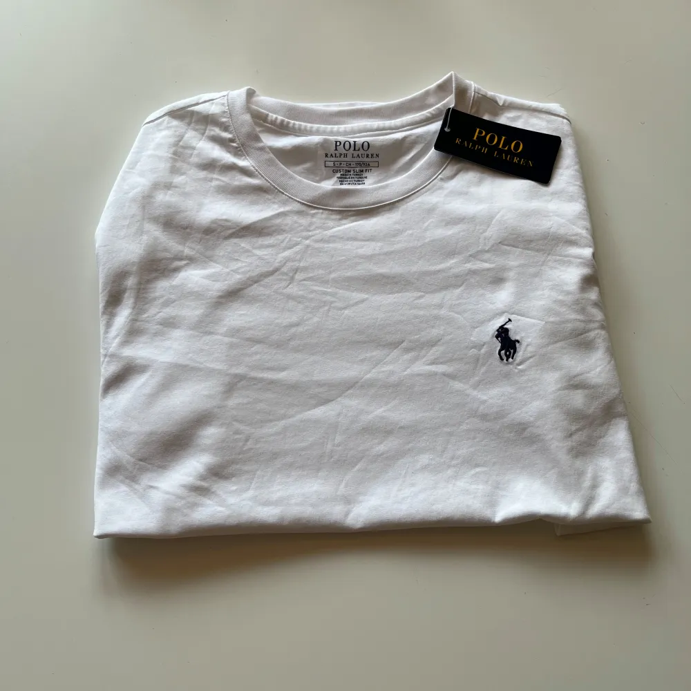 En helt ny fin vit polo Ralph lauren t-shirt med prislapp kvar.  Skriv vid några funderingar mitt pris 599kr går att förhandla:) strl S. T-shirts.