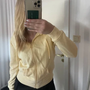 Gul hoodie från primark - Säljer en supermjuk och bekväm gul hoodie från primark . Den har en dragkedja framtill och en praktisk ficka på magen. Perfekt för en avslappnad stil eller mysiga dagar hemma. 🧡