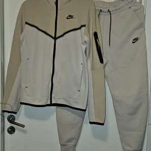 Nike tech fleece dress St x-small/small - Nike tech fleece dress  Tröja st xsmall  Byxa st small Cremefärgad/beige  Finns några revor på benet bilder finns  Inget som direkt syns el stör funktionen  Nån noppra som ör lätt o ta bort  Fungerar utmärkt ett bra tag till  Hund finns I hemmet  