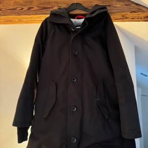 Svart dunjacka stl s  - Svart halvlång dunjacka (okänt franskt märke, se logga). Äkta dun. Stilren, snygg och varm. Fint skick! 