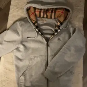 Tjena, säljer denna asfeta Burberry Zip Hoddien som ej används, använd ett fåtal gånger. Fick den i present då jag fyllde år, Stl S men passar M🫡