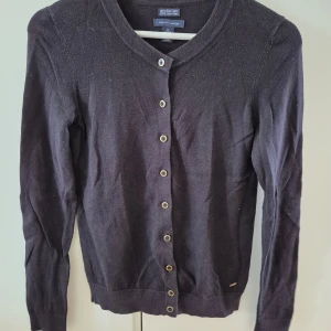 Kofta Tommy Hilfiger - Svart kofta med guld färgad knappar från Tommy Hilfiger. Tunn och stechbar. Mjuk material. Använd några gånger. Storlek XS. 100% bomull. 