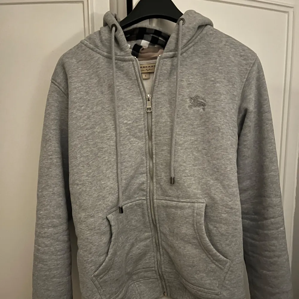 Säljer en grå Burberry zip hoodie i storlek S. Hoodie är i bra skick och av hög kvalitet, perfekt för den som gillar stil och komfort. Klassisk design med Burberrys ikoniska detaljer.  Skicka PM INNAN ni köper!. Hoodies.