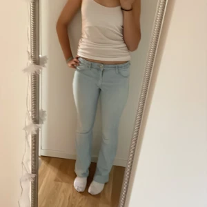 Ljusblå jeans från H&M - Säljer ett par ljusblå jeans från H&M. De har en flared leg och är lågmidjade med justerbar midja. Perfekta för en avslappnad stil och passar till de flesta tillfällen. Sköna och snygga!