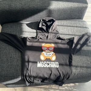 Moschino hoodie - Storlek 152 till barn. 500kr men pris kan diskuteras. Skick 6/10 man kan se att den är använd men inga skador. Den är äkta 