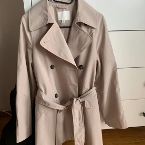 Trenchcoat  - Trenchcoat från H&M i storlek 34. Stor i storleken. Använd vid ett tillfälle så i nyskick. 