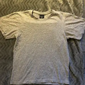 Säljer en enkel och bekväm grå t-shirt från Basic. Perfekt för vardagen med mjuk bomullskänsla. T-shirten har korta ärmar och en rund halsringning. Passar bra till både jeans och shorts!💗storleken är 146/152 men passar även mig som normalt har XS/S